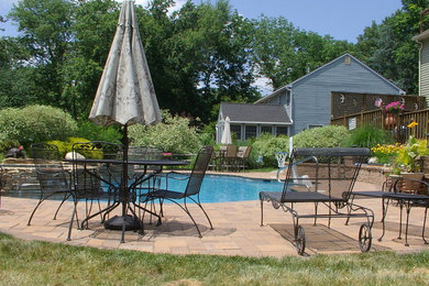 Pool - large backyard brick and custom-shaped pool idea in Philadelphia