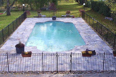 Foto de piscina de tamaño medio rectangular en patio trasero con suelo de baldosas