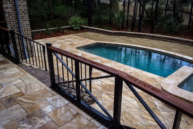 Modelo de piscina costera en patio trasero con adoquines de piedra natural