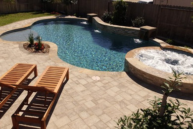 Idee per una piscina classica personalizzata di medie dimensioni e dietro casa con una vasca idromassaggio e pavimentazioni in cemento