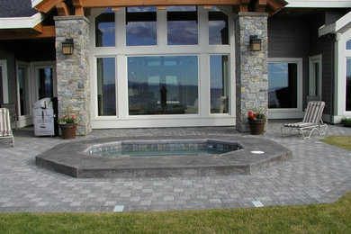 Idee per una piscina stile marino rotonda dietro casa con una vasca idromassaggio e pavimentazioni in cemento