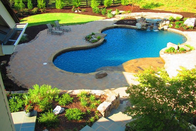 Huge elegant backyard stone and custom-shaped hot tub photo in Atlanta