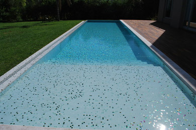 Ejemplo de casa de la piscina y piscina contemporánea rectangular en patio trasero con suelo de baldosas