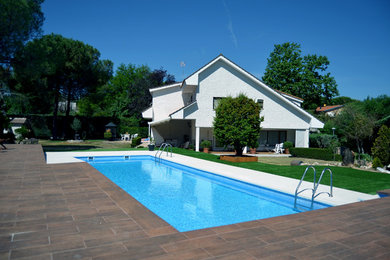 Diseño de casa de la piscina y piscina alargada minimalista grande rectangular en patio delantero con suelo de baldosas