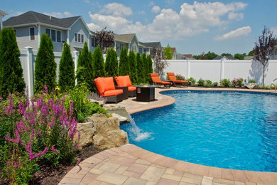 Foto de piscina con fuente clásica renovada grande tipo riñón en patio trasero con adoquines de hormigón