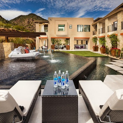 Inspiration for a huge southwestern backyard stone and custom-shaped infinity pool fountain remodel in Phoenix