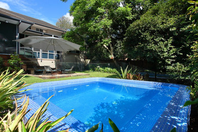 Пример оригинального дизайна: маленький прямоугольный бассейн на заднем дворе в стиле модернизм с мощением клинкерной брусчаткой для на участке и в саду