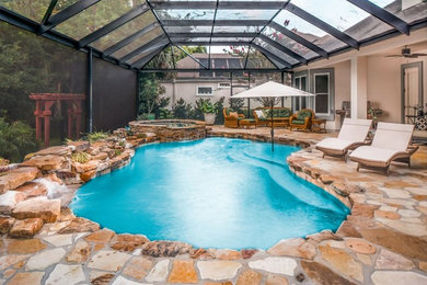 Large island style backyard stone and custom-shaped natural pool fountain photo in Jacksonville