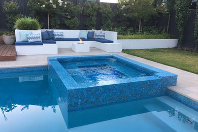 Ejemplo de piscina minimalista grande rectangular en patio trasero con adoquines de hormigón