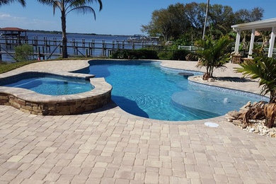 Modelo de piscinas y jacuzzis naturales grandes a medida en patio trasero con granito descompuesto