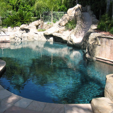 Pool and patio with stone / rock walls and deck
