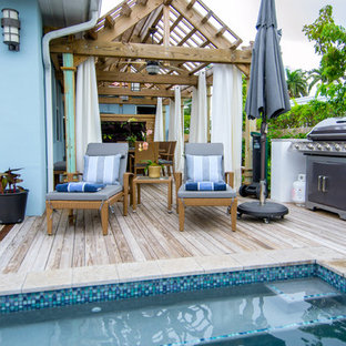 Foto di una piscina tropicale rettangolare di medie dimensioni e dietro casa con pedane