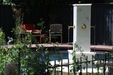 Foto de piscina clásica redondeada con adoquines de ladrillo