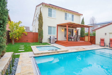 Idee per una piscina monocorsia chic rettangolare di medie dimensioni e dietro casa con una vasca idromassaggio e pavimentazioni in pietra naturale