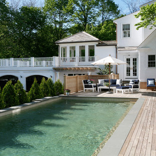 Pool house - large traditional backyard rectangular lap pool house idea in Boston with decking