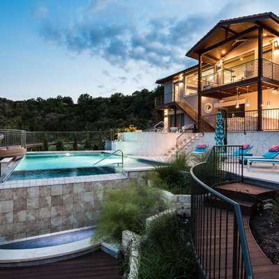 Large tuscan backyard tile and rectangular aboveground hot tub photo in Austin