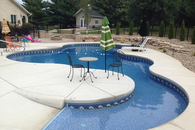 Imagen de piscina alargada contemporánea de tamaño medio a medida con losas de hormigón