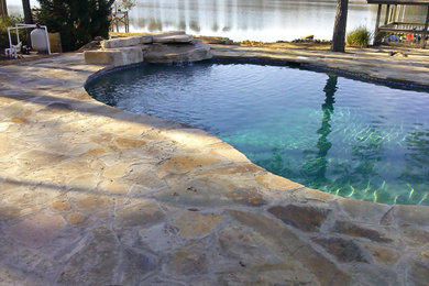 Pool landscaping - mid-sized traditional backyard stone and custom-shaped natural pool landscaping idea in Other