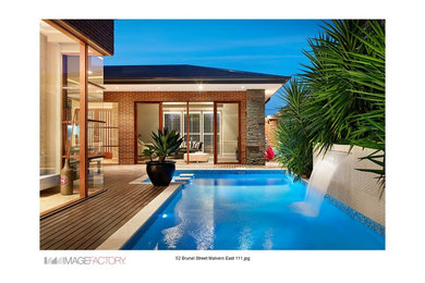Kleiner Moderner Infinity-Pool hinter dem Haus in rechteckiger Form mit Wasserspiel und Natursteinplatten in Melbourne