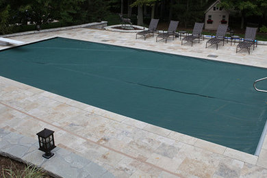 Cette image montre une piscine arrière traditionnelle de taille moyenne et rectangle avec des pavés en pierre naturelle.