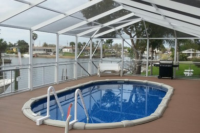 Inspiration for a mid-sized tropical backyard round pool remodel in Tampa with decking
