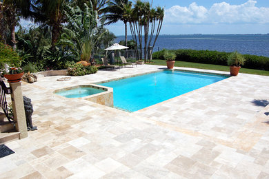 Huge island style backyard tile and rectangular hot tub photo in Tampa