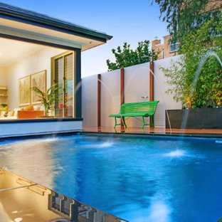 Esempio di una piccola piscina naturale moderna personalizzata in cortile con fontane e pedane