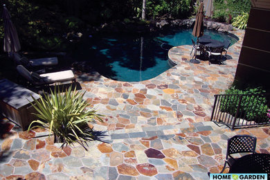 На фото: естественный бассейн произвольной формы на заднем дворе в средиземноморском стиле с покрытием из каменной брусчатки с