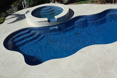 Pool - mid-sized tropical backyard concrete pool idea in Other