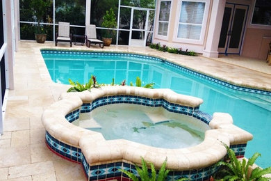 Diseño de piscinas y jacuzzis de tamaño medio a medida en patio trasero con adoquines de hormigón