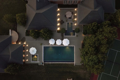 Ejemplo de piscinas y jacuzzis infinitos clásicos de tamaño medio rectangulares en patio trasero con adoquines de hormigón