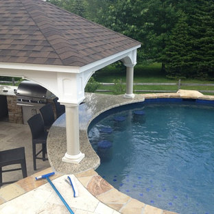 Example of a large classic backyard stone and custom-shaped natural hot tub design in Philadelphia