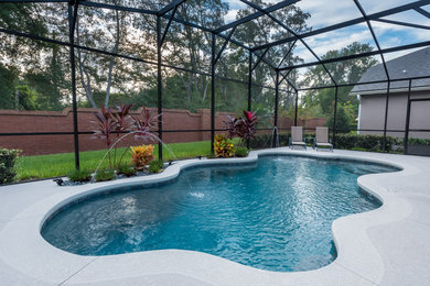 Medium sized classic indoor custom shaped swimming pool in Orlando with a water feature.