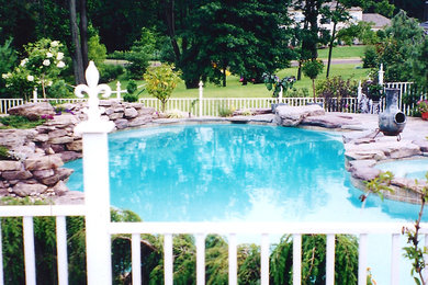 Ejemplo de piscinas y jacuzzis de tamaño medio a medida en patio trasero con adoquines de hormigón