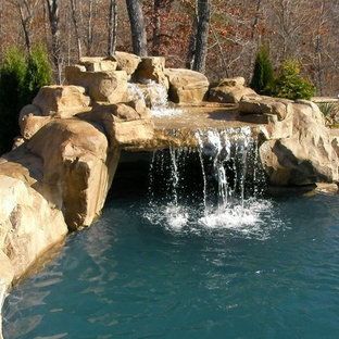 Ispirazione per una grande piscina tropicale personalizzata dietro casa con fontane e pavimentazioni in pietra naturale
