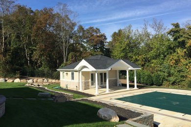 Pool house - large traditional backyard tile and rectangular lap pool house idea in New York