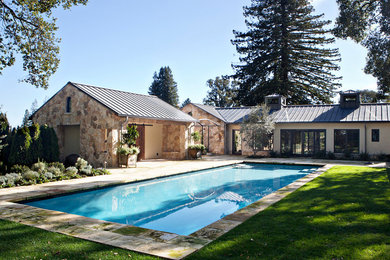 Inspiration pour une grande piscine arrière rustique rectangle avec des pavés en pierre naturelle.