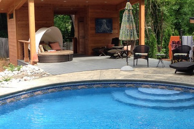 Imagen de casa de la piscina y piscina actual redondeada en patio trasero con adoquines de hormigón