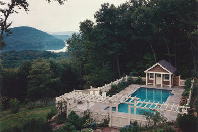 Diseño de casa de la piscina y piscina alargada actual de tamaño medio rectangular en patio trasero con adoquines de piedra natural