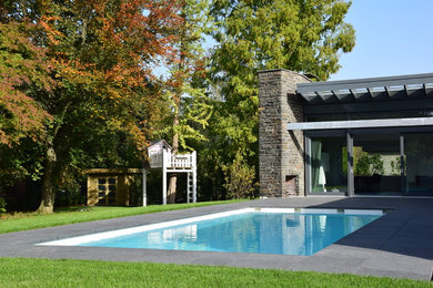 Mittelgroßer Moderner Pool hinter dem Haus in rechteckiger Form mit Granitsplitt in Sonstige