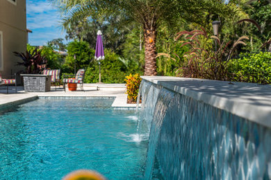 Inspiration for a medium sized world-inspired back custom shaped swimming pool in Orlando with concrete slabs.