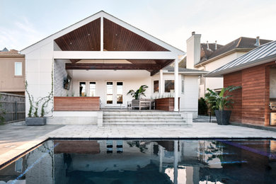 Ejemplo de piscinas y jacuzzis alargados minimalistas de tamaño medio rectangulares en patio trasero con adoquines de hormigón