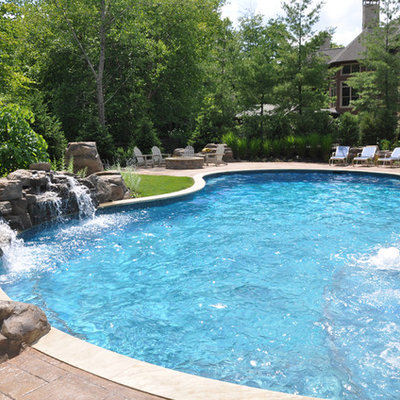 Example of a large mountain style backyard concrete paver and custom-shaped natural hot tub design in Cleveland