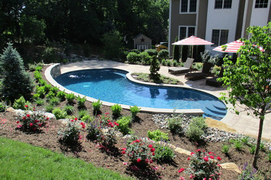 На фото: большой бассейн произвольной формы на заднем дворе в стиле модернизм с мощением клинкерной брусчаткой