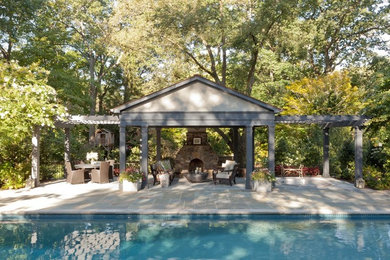 Diseño de piscina alargada de estilo americano grande rectangular en patio trasero con adoquines de piedra natural