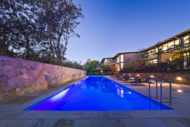 Foto de piscina alargada contemporánea grande rectangular con adoquines de piedra natural