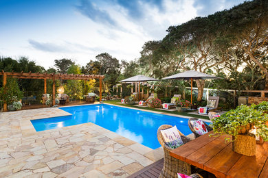 Foto de piscina con fuente natural costera grande rectangular en patio trasero con adoquines de piedra natural