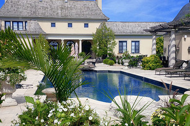 Foto de piscina con fuente tradicional renovada grande a medida en patio trasero con adoquines de piedra natural