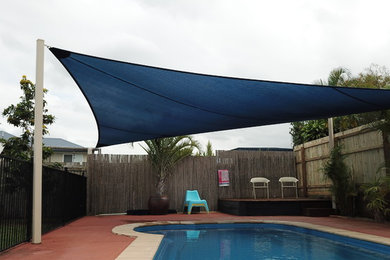 Modelo de piscina alargada clásica de tamaño medio a medida en patio trasero con adoquines de hormigón