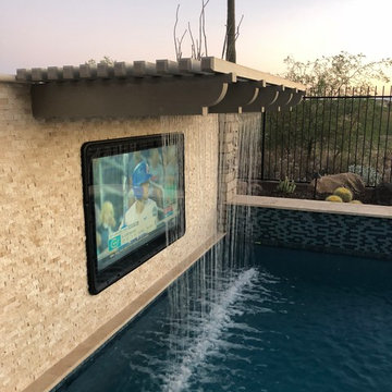 Pool TV set in stone wall, enclose in weatherproof case with waterfall feature.